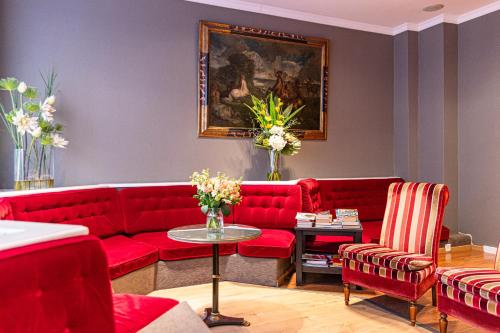 a living room with red couches and a table at Hotel Claude Bernard Saint-Germain in Paris