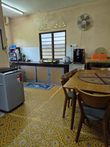 a kitchen and dining room with a table and chairs at Homestay Sayang Salmah in Balik Pulau