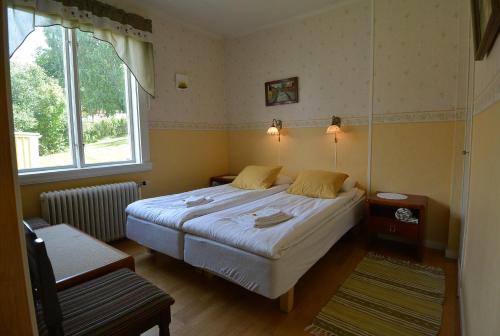 ein Schlafzimmer mit einem Bett und einem Fenster in der Unterkunft Pensionat Åsgården in Lyrestad