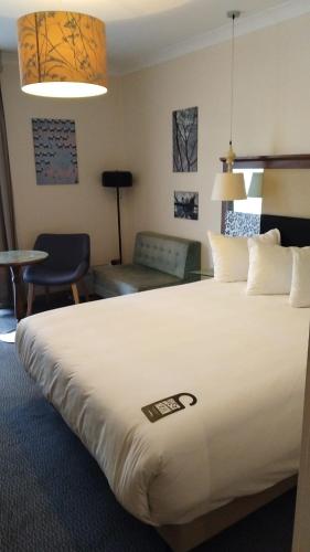 a hotel room with a large bed and a living room at London Thames Lodge by Dancenter near Thorpe Park in Staines
