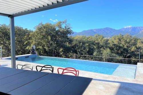 Villa con piscina con montañas de fondo en Villa Montinu Di Caramontinu, en Sainte-Lucie de Porto-Vecchio