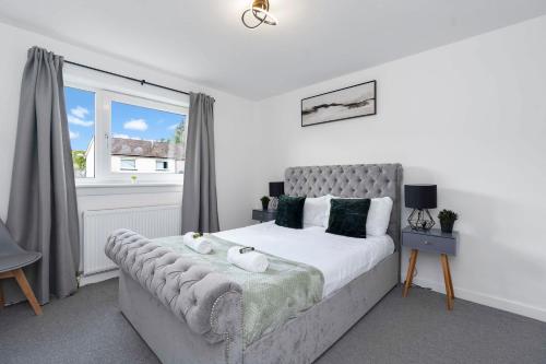 a bedroom with a large bed and a window at Vacant Nests The Livingston Retreat Wi-fi in Uphall