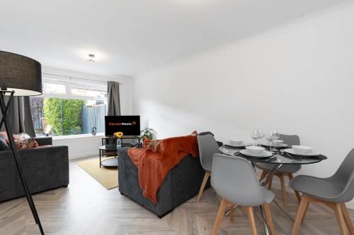 a living room with a table and a couch at Vacant Nests The Livingston Retreat Wi-Fi in Uphall