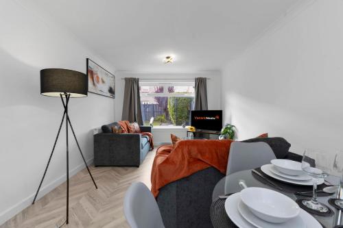 a living room with a couch and a table with chairs at Vacant Nests The Livingston Retreat Wi-Fi in Uphall