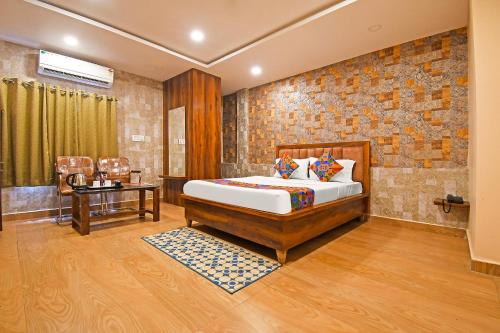 a bedroom with a bed and a brick wall at FabHotel Royal Lagoon - Near railway station gate number 1 in Bhubaneshwar