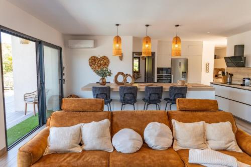 a living room with a brown couch with pillows at Villa Tinoeva Mare di Conca in Conca