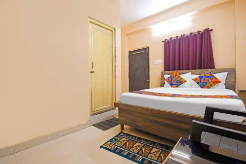 a bedroom with a large bed with colorful pillows at FabHotel Royal Lagoon - Near railway station gate number 1 in Bhubaneshwar
