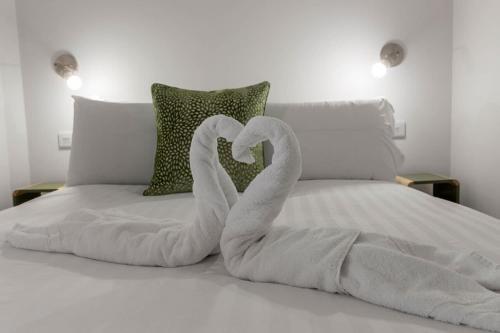 two towel swans making a heart on a bed at Exeter Escape - City Centre Apartment- Short Stays UK Ltd in Exeter