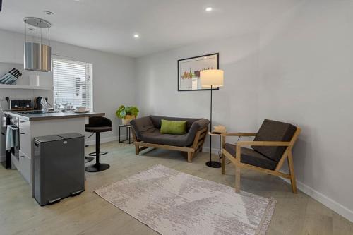 a living room with a couch and chairs and a kitchen at Exeter Escape - City Centre Apartment- Short Stays UK Ltd in Exeter