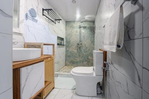 a bathroom with a toilet and a sink and a shower at Comfortable House in Trou-aux-Biches with Terrace in Trou aux Biches