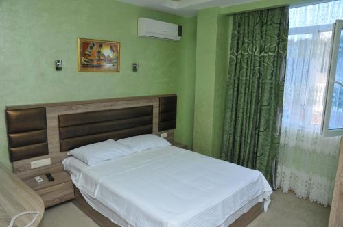 a green bedroom with a bed and a window at Black Sea Star Batumi in Batumi