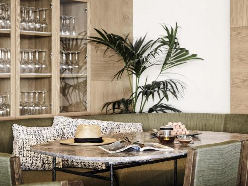 a table in a restaurant with a hat on it at NIKO Seaside Resort MGallery in Agios Nikolaos