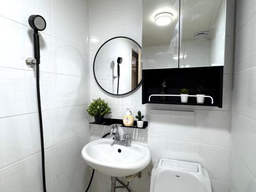 a white bathroom with a sink and a mirror at Haus HAVEN in Seoul