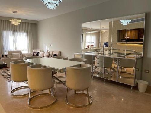 a dining room with a white table and chairs at Beverly hills westtown in Sheikh Zayed