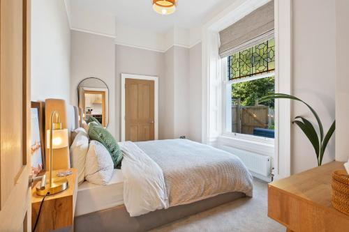 a white bedroom with a bed and a window at Torquay Beachside Hot Tub Stay in Stokeinteignhead