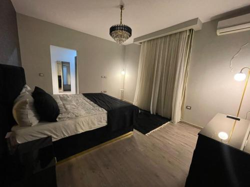 a bedroom with a bed and a large window at Beverly hills westtown in Sheikh Zayed