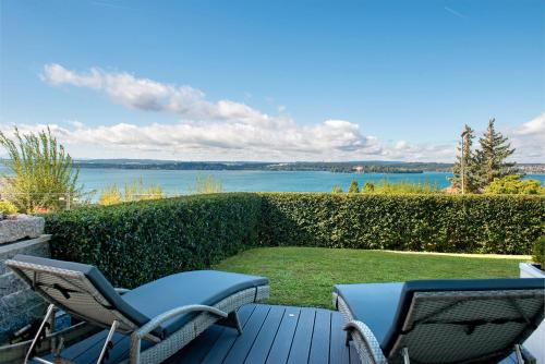 a patio with two chairs and a view of the water at Krautter in Uhldingen-Mühlhofen