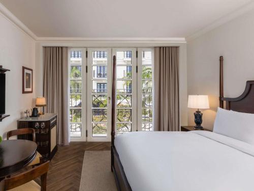 a bedroom with a bed and a desk and a window at Sofitel Legend Casco Viejo, Panama City in Panama City