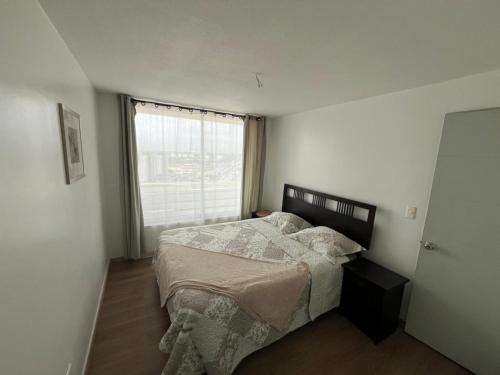 a bedroom with a bed and a window at La Serena, Vista al mar y piscina in Coquimbo