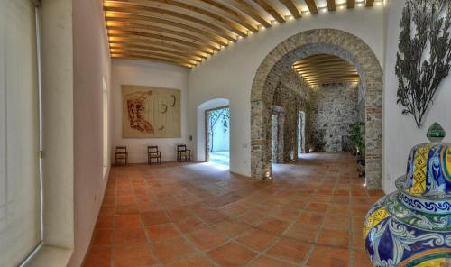 a hallway with an archway and a vase in a room at Hotel Boutique Casareyna in Puebla