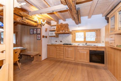 a kitchen with wooden cabinets and a wooden table at Serrai Lodge in Sottoguda