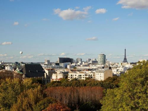 a view of a city with the eiffel tower at Domaine de la Reine Margot Paris-Issy - MGallery Collection in Issy-les-Moulineaux