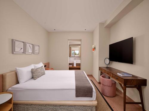 a bedroom with a bed and a desk and a television at Paloma Grida in Belek