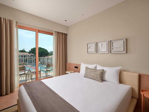 a hotel room with a bed and a balcony at Paloma Grida in Belek