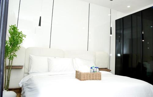 a bedroom with a white bed with a basket on it at Winters Apartment in Abuja