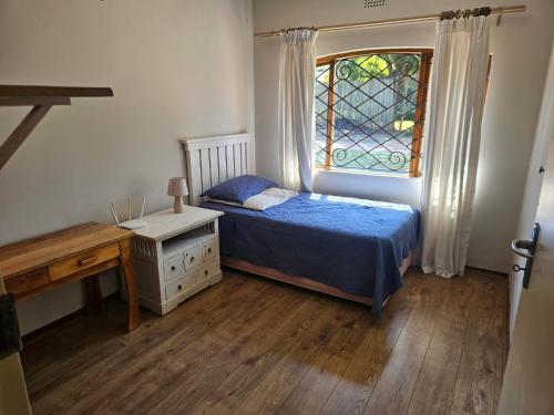ein kleines Schlafzimmer mit einem Bett und einem Fenster in der Unterkunft Family Home in Roodepoort