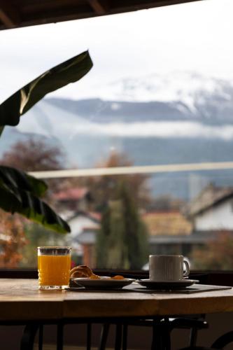 ein Tisch mit einer Tasse Kaffee und einem Glas Orangensaft in der Unterkunft Hotel Cordillera in El Bolsón