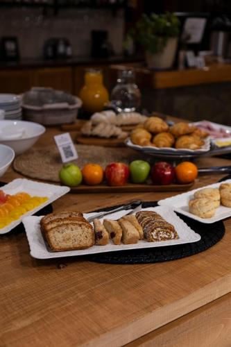 a table topped with different types of bread and fruit at Hotel Cordillera in El Bolsón