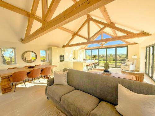 a living room with a couch and a dining room at Serene Cotswold Escape 360 Views Private Acres Dog Friendly in Halford