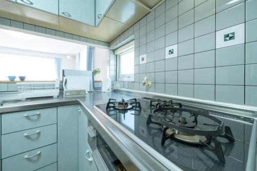 a kitchen with a stove and a counter top at Asahikawa House 1F in Asahikawa