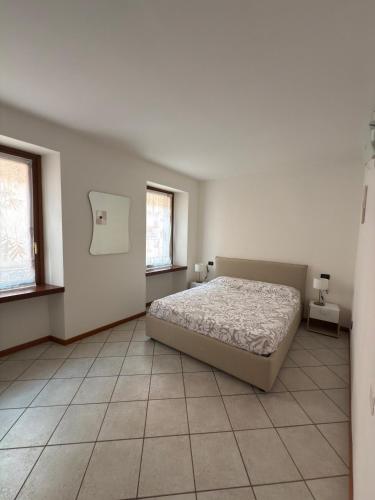 a bedroom with a bed and two windows at The Lake Stop in Marone