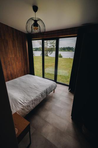 a bedroom with a bed and a large window at Laimeskalni in Koknese