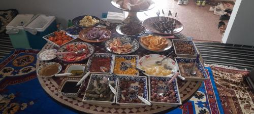 a table with a bunch of plates of food on it at Bivouac Luxe Le Ciel Bleu in Hassilabied