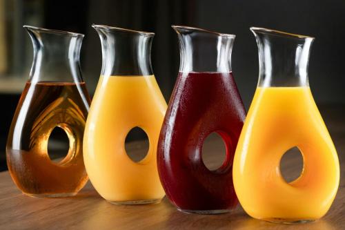 four different colored vases sitting on a table at AC Hotel by Marriott Cartagena in Cartagena