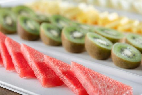 a white plate topped with water melons and other fruit at AC Hotel by Marriott Cartagena in Cartagena