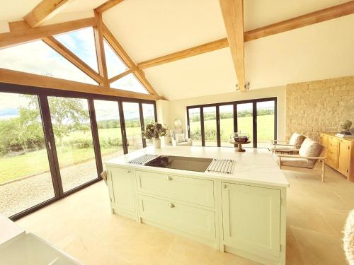 a kitchen with a sink in a room with windows at Serene Cotswold Escape 360 Views Private Acres Dog Friendly in Halford