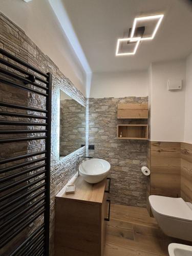 a bathroom with a sink and a toilet and a tub at Baita di noni in Valdisotto