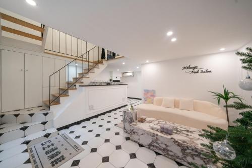 a living room with a couch and a staircase at Tonight Homestay South Shanxi Road Shanghai in Shanghai