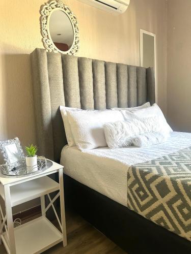 Un dormitorio con una cama grande con un espejo en la pared. en Riverside Gardens 2 bedroom Home, en Nelspruit