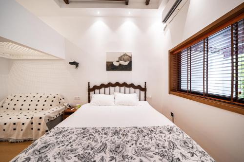 a bedroom with a bed and a window at Tonight Homestay South Shanxi Road Shanghai in Shanghai