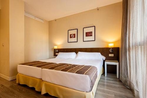 a hotel room with a large bed and a window at Vértice Sevilla in Seville