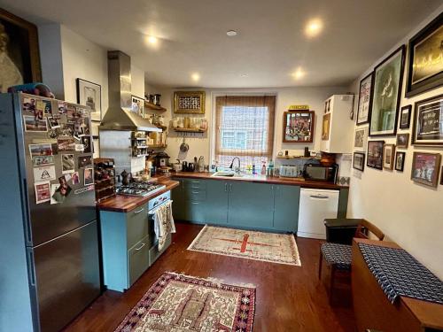 a kitchen with a refrigerator and a counter top at Open plan stylish urban flat in London