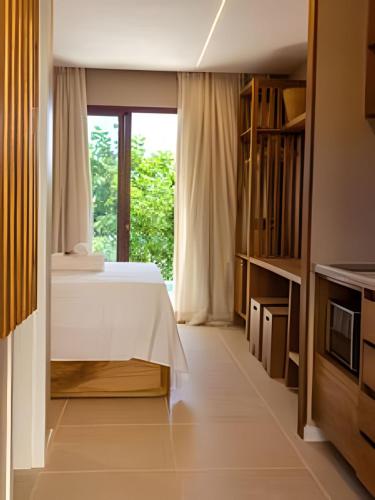 a bedroom with a bed and a window at MAR DÁ LIBERDADE com Amerigo Vespucci in Morro de São Paulo