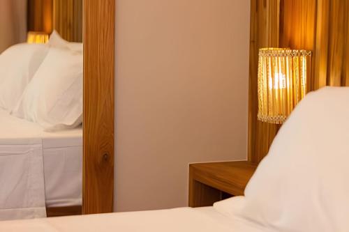 a bedroom with a mirror and a bed at MAR DÁ LIBERDADE com Amerigo Vespucci in Morro de São Paulo
