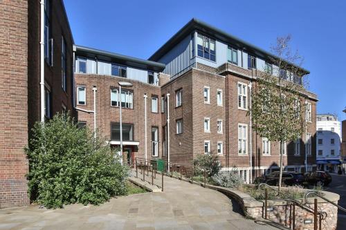 a large brick building with a sidewalk in front of it at For Students Only - Library Lofts in Exeter in Exeter