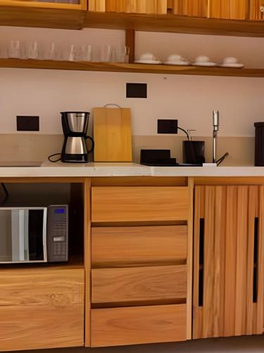 a kitchen with a counter and a microwave at MAR DÁ LIBERDADE com Amerigo Vespucci in Morro de São Paulo